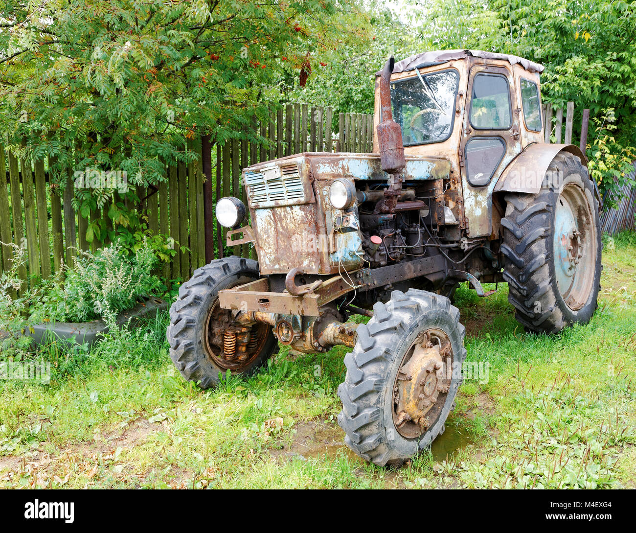 Vecchio trattore in strada rurale giorno di estate Foto Stock
