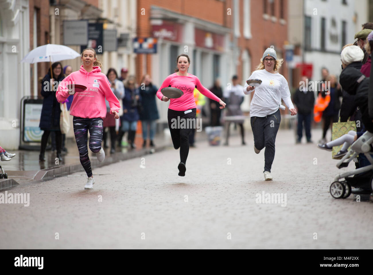 L annuale Lichfield pancake gara prendono posto nel foro Street Foto Stock