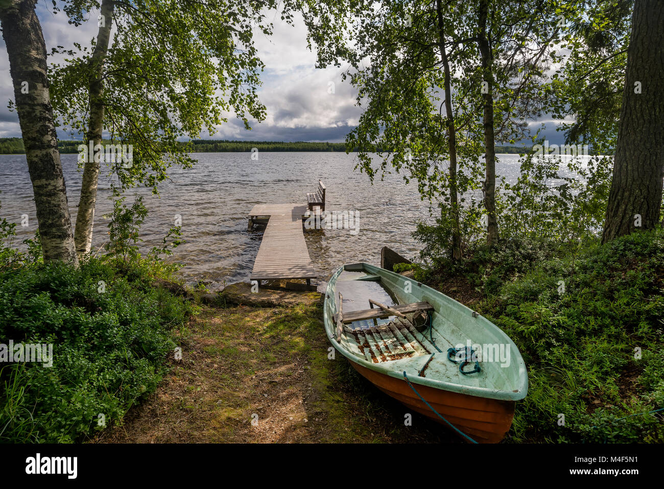 Barca a remi e panca in legno in Rantasalmi, Distretto dei Laghi, Finlandia Foto Stock