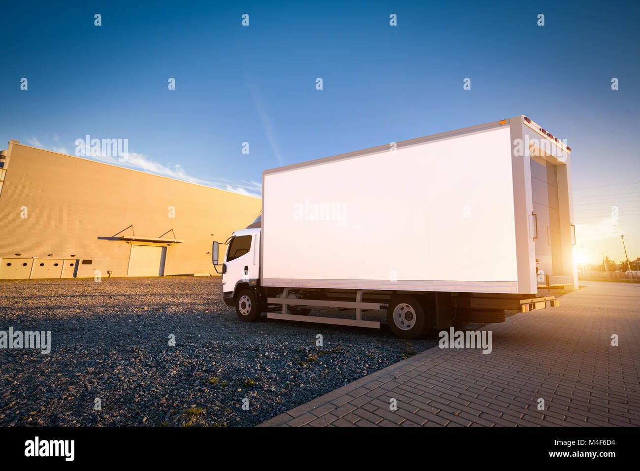 Recapito commerciale con carrello vuoto bianco sul rimorchio carico di parcheggio. Foto Stock