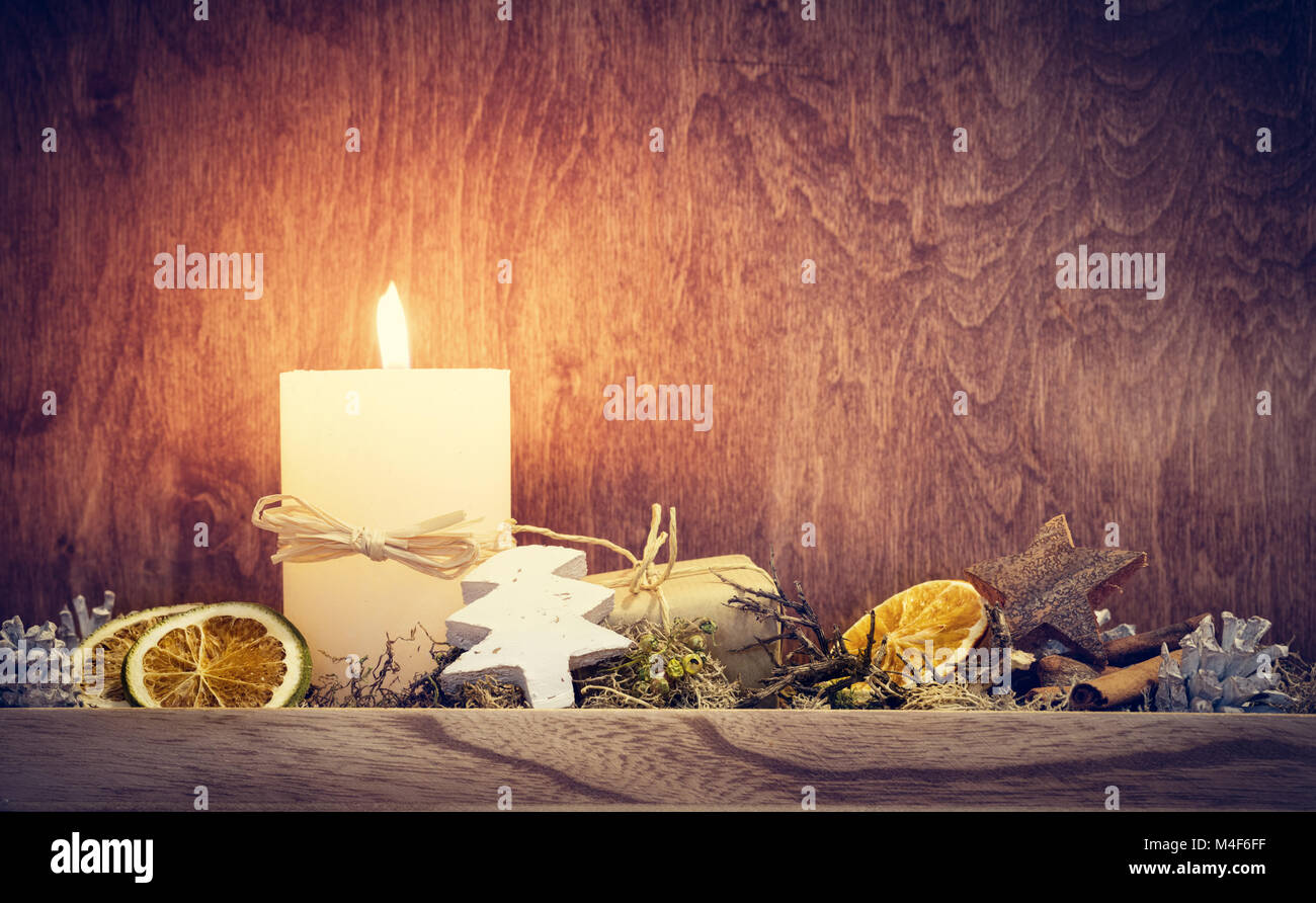 Chistmas Decorazione con candela incandescente sulla parete in legno sfondo Foto Stock