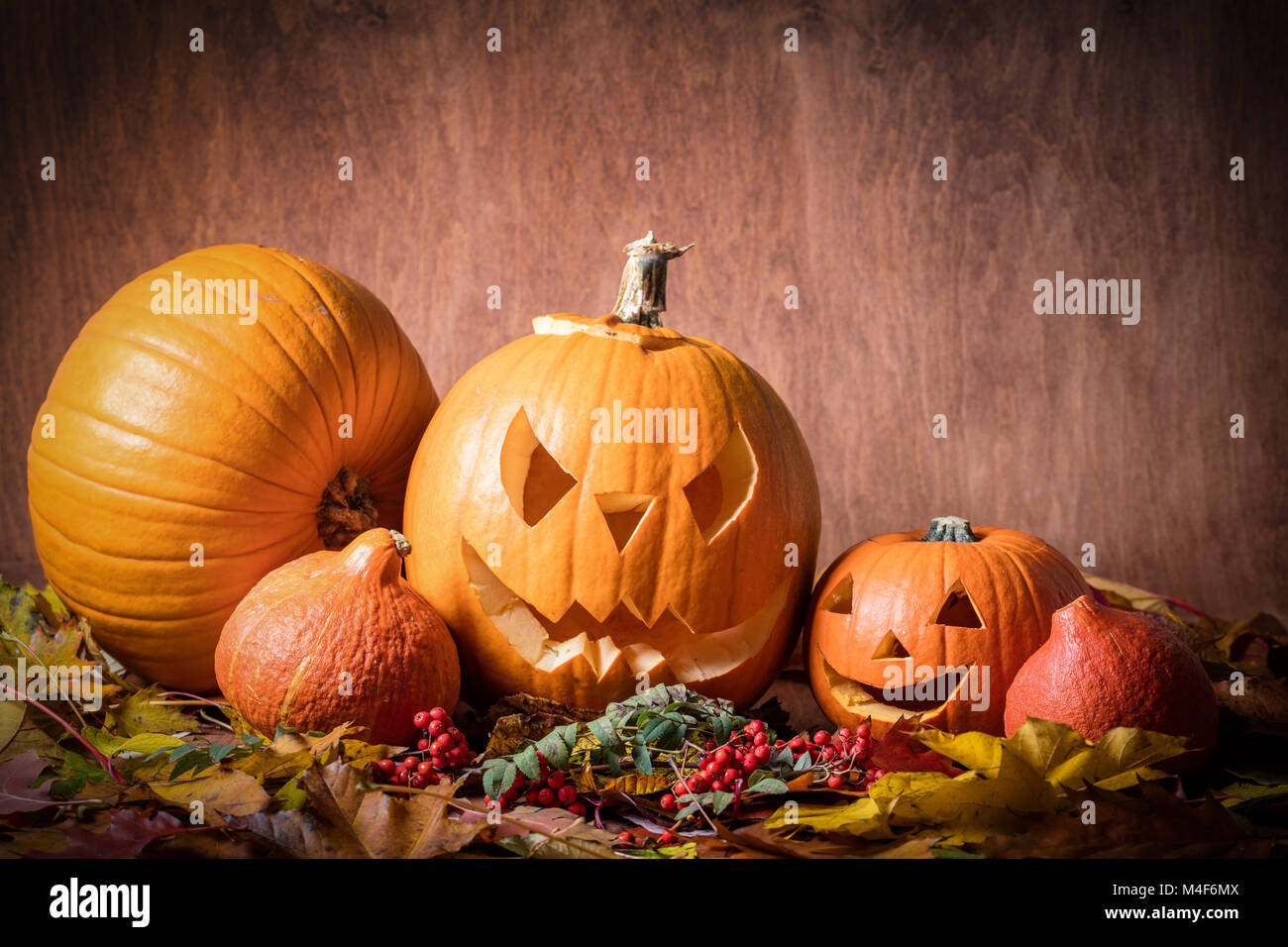 Zucche di Halloween, scolpiti jack-o-lantern in foglie di autunno Foto Stock
