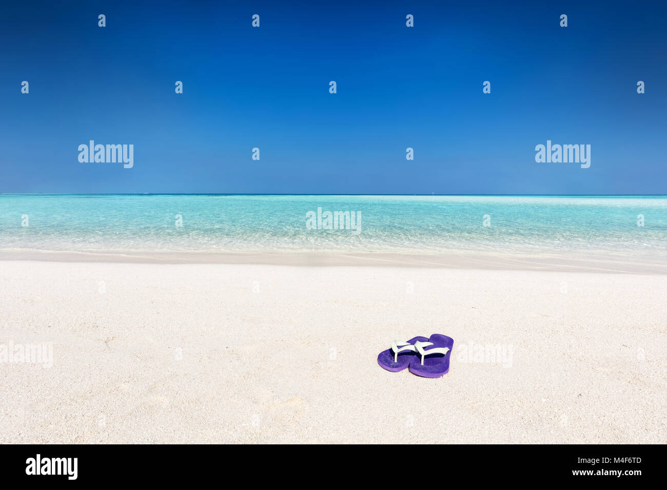 Flip-flop sulla sabbia sulla spiaggia tropicale delle Maldive Foto Stock