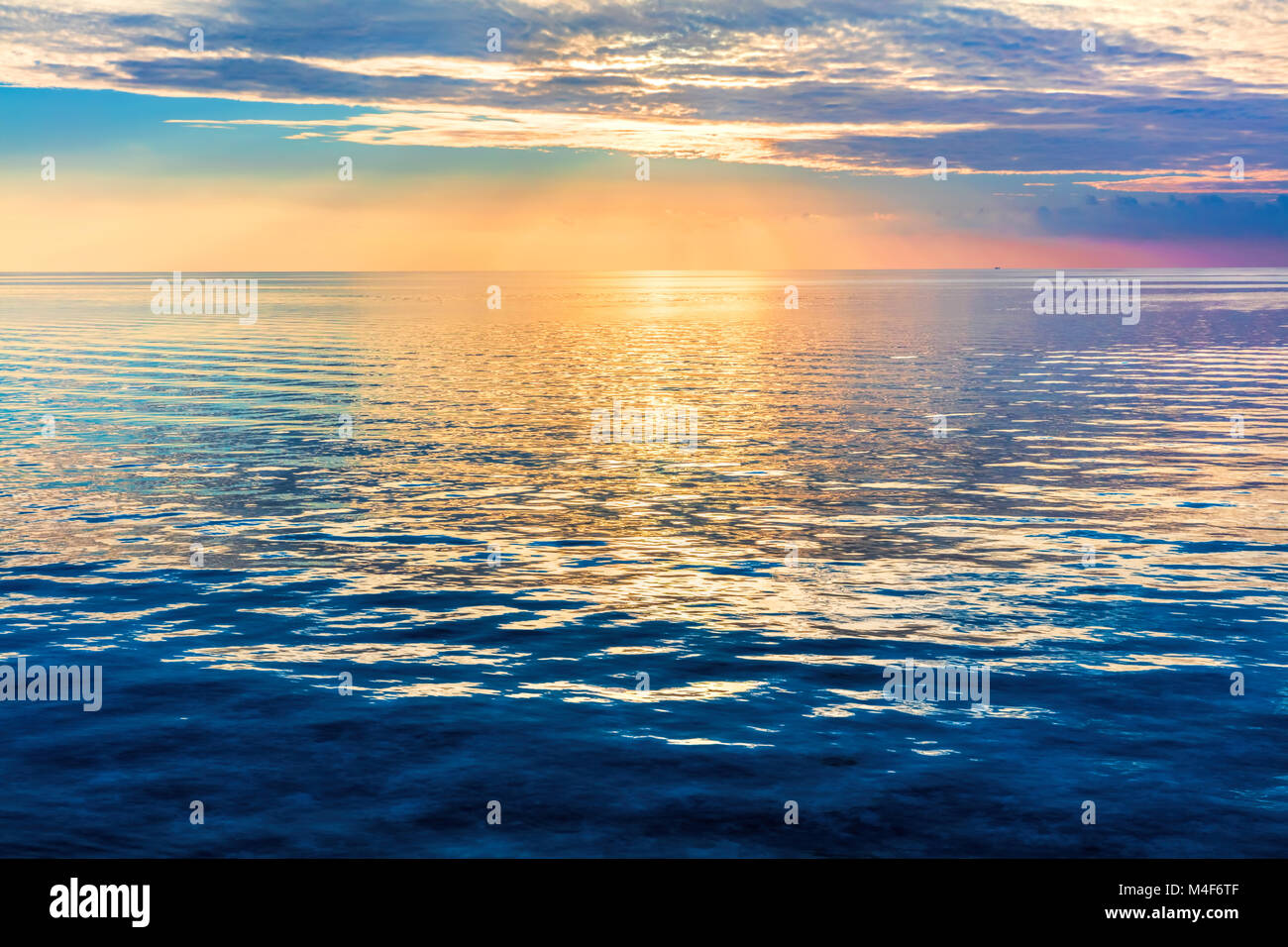 Calma oceano al tramonto. Cielo drammatico Foto Stock