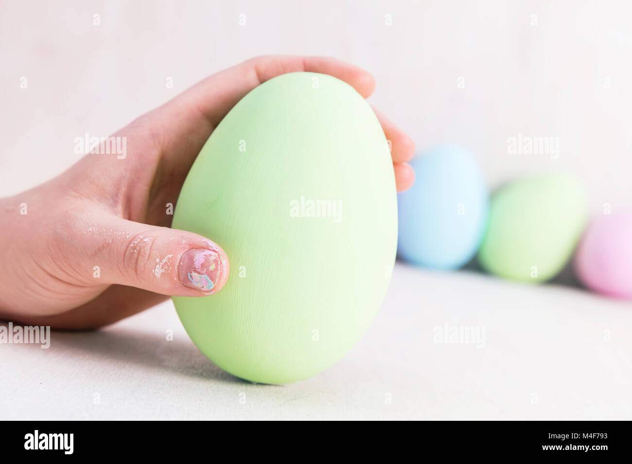 Mano che regge un uovo di Pasqua. Foto Stock