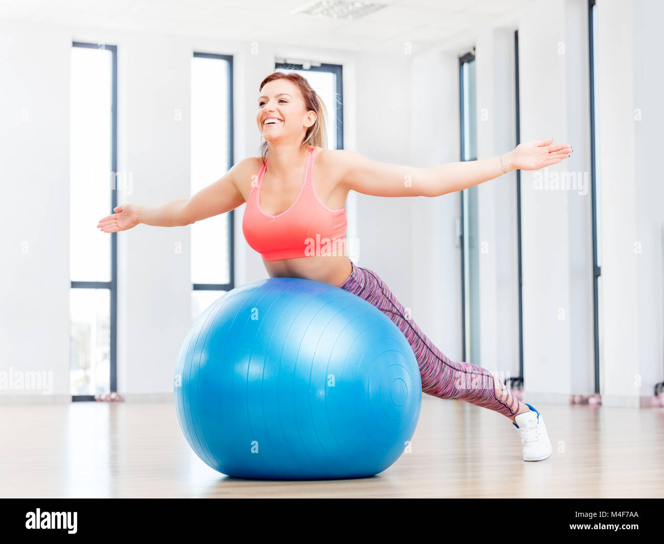 Donna sorridente con formazione fitball al fitness club. Foto Stock