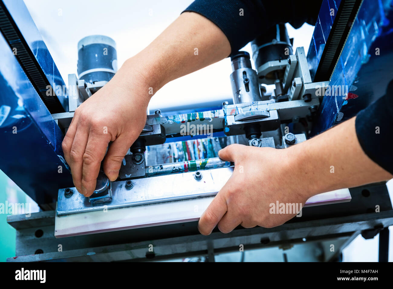 Lavoratore impostazione stampa screening macchina in metallo Foto Stock