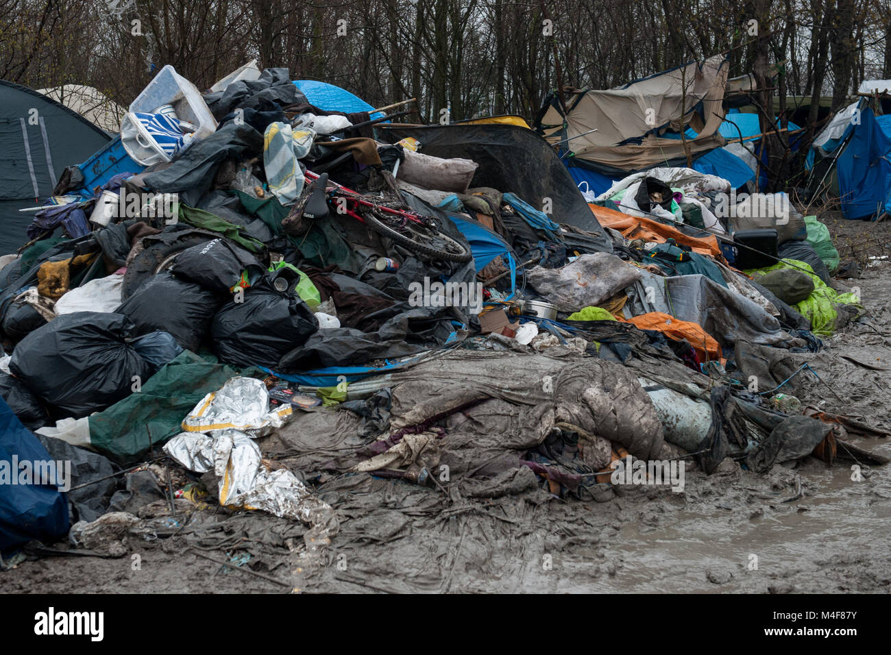 Grande-Synthe, nel nord della Francia. Il 31 gennaio 2016. Una vista generale della Grande-Synthe Refugee Camp vicino al porto di Dunkerque in Francia settentrionale. Nel campo condizioni sono grim in parte a causa di fango spesso e la mancanza di servizi di base. Le famiglie vivono in pioggia inzuppato tende e stringersi intorno a piccoli incendi per il calore base. Foto Stock