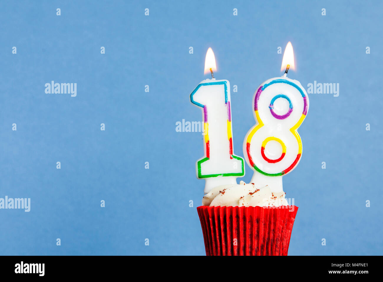 Numero 18 Compleanno Candela In Una Tortina Contro Uno Sfondo Blu Foto Stock Alamy