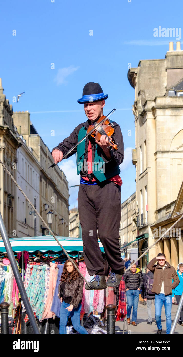 Bath, Regno Unito. Il 16 febbraio 2018. Una luminosa gli inverni di giorno nella vasca da bagno al di fuori delle terme romane. Kwabana Lindsay esegue il suo agire nel centro di Bath. Il 'Fiddler su una fune' ha eseguito tutto il counntry, mostrando la propria forma di musical equilibistics. Credito: JMF News/Alamy Live News Foto Stock