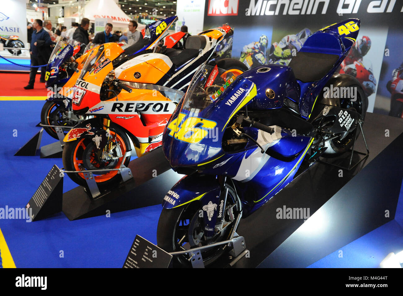 Racing Superbike sul display a Carole Nash MCN London Motorcycle Show che si sta svolgendo a ExCel di Londra, Regno Unito. Il blue superbike in primo piano è una Yamaha M1 990cc che è stato cavalcato da Valentino Rossi e lo ha aiutato a vincere nove gare nella stagione 2004. L'arancione/rosso superbike è una Honda RC213V 1000cc che è stato guidato da Marc Marquez e lo ha aiutato a vincere sette gare nella stagione 2017. La mostra attira circa 36.000 visitatori e offre una vasta varietà di motociclette, scooter, motociclette e personalizzati one-off chopper. Foto Stock