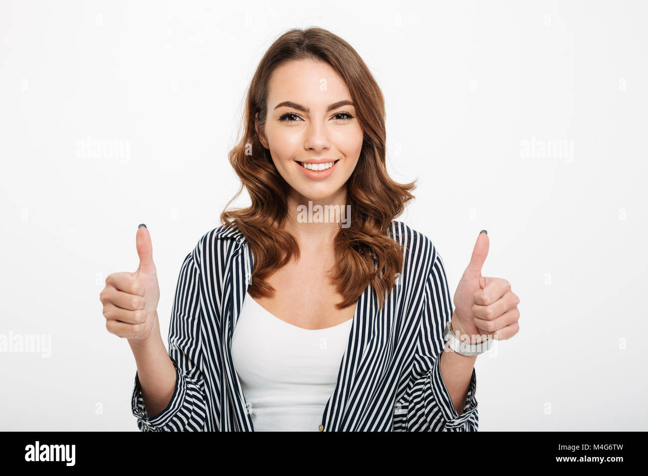 Ritratto di una gioiosa ragazza casual mostra Thumbs up gesto isolato su sfondo bianco Foto Stock