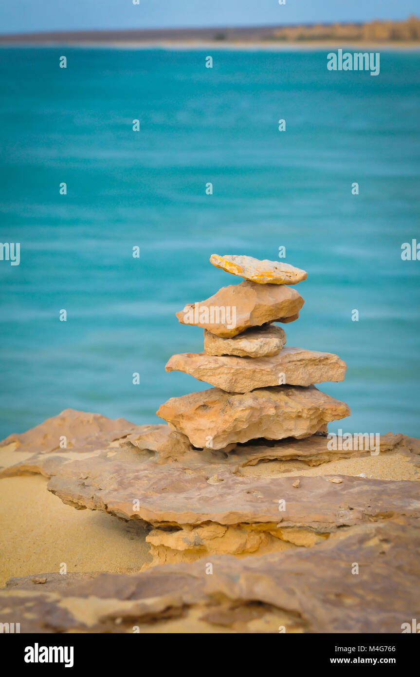 La meditazione, relax, o la vita il concetto di equilibrio con la pila di rocce contro il paesaggio marino Foto Stock