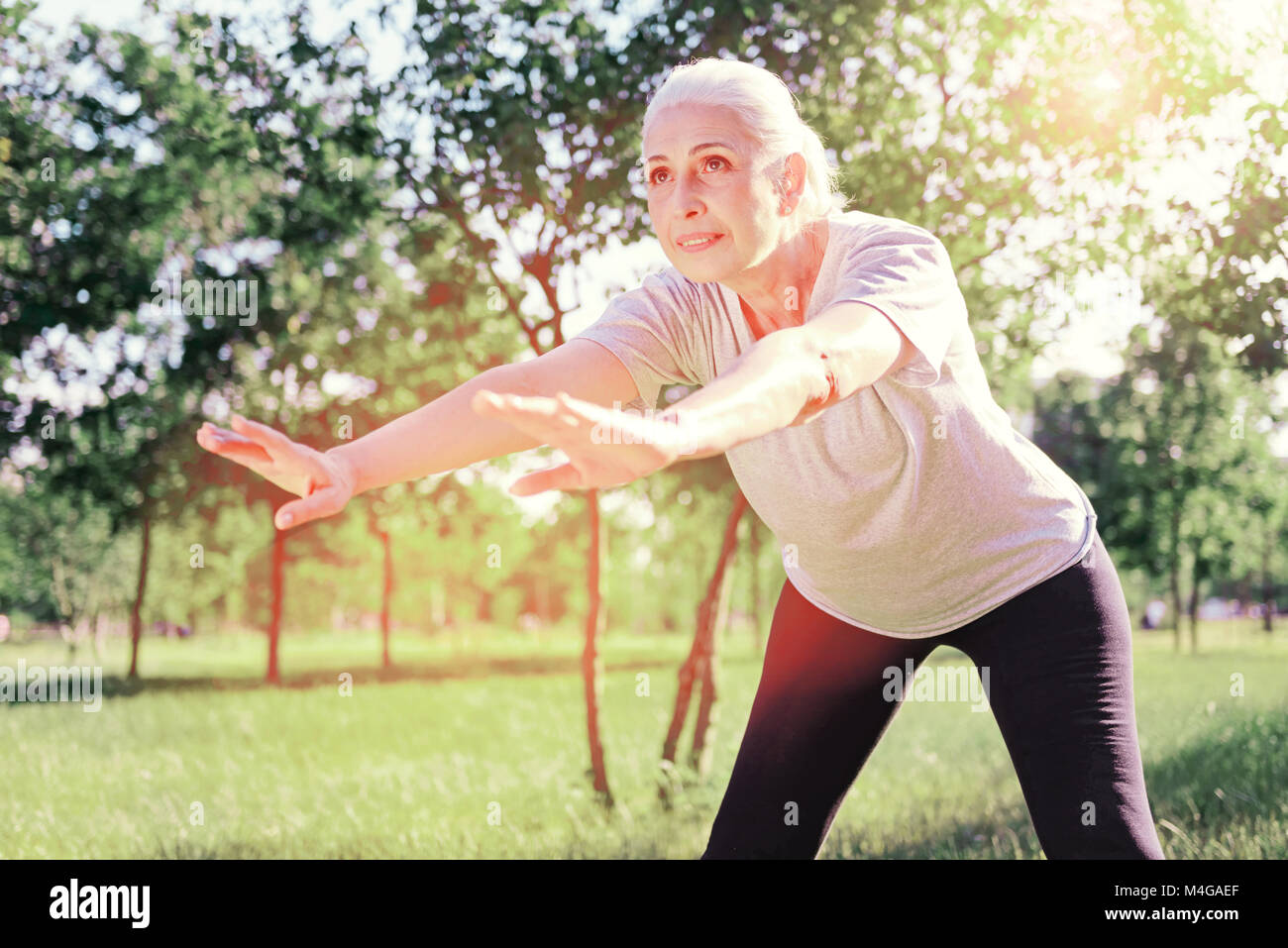 Concentrato donna anziana la piegatura in avanti Foto Stock