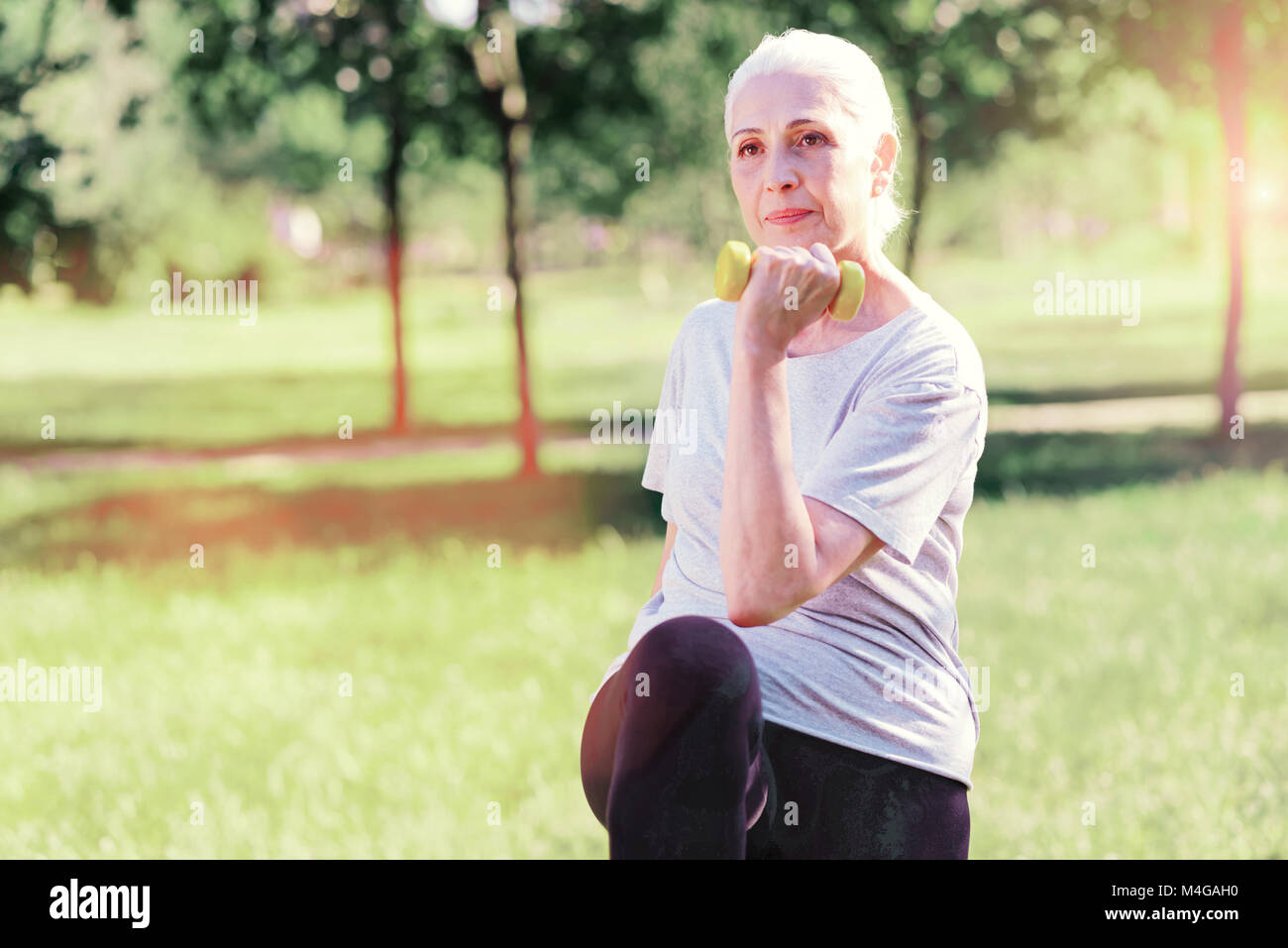Concentrato donna anziana facendo esercizi Foto Stock