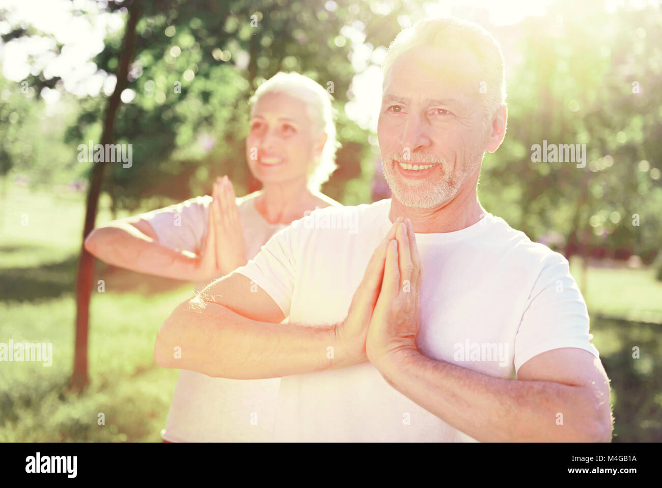 Famiglia allegra meditando in aria fresca Foto Stock