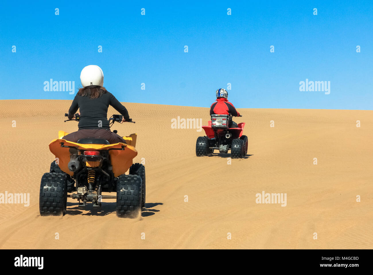 Quad la guida di persone - Due ciclisti felice nel deserto di sabbia. Foto Stock