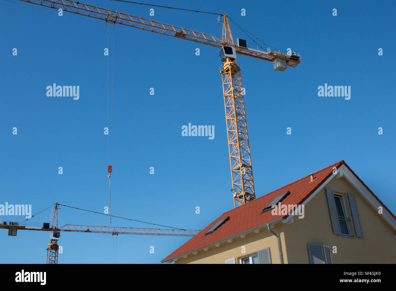 Giallo eracted gru su un tetto rosso impianto costruito nel cielo bluw a luce diurna, shot 2017 Foto Stock