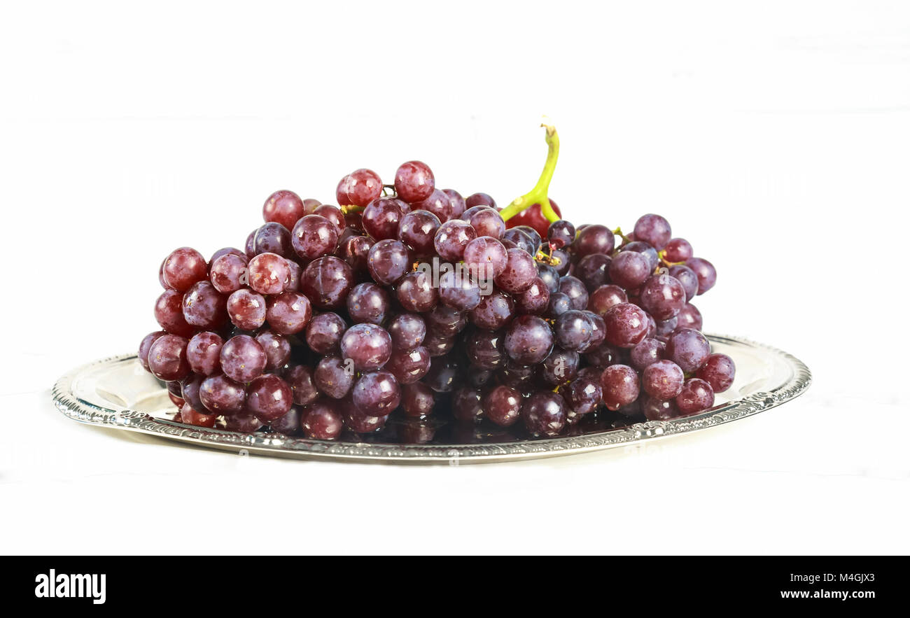 Bicchiere di vino e uva, isolato su bianco Foto Stock