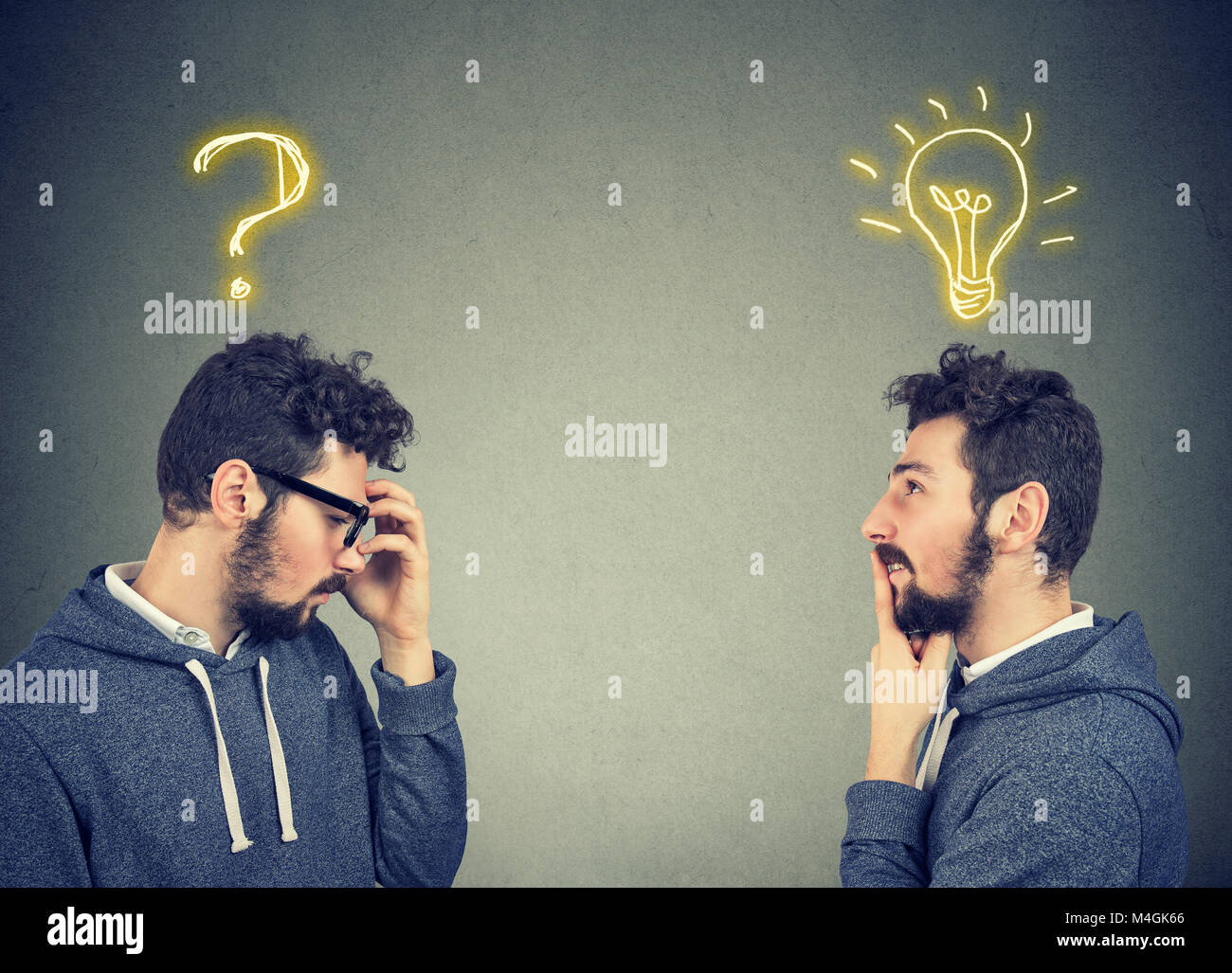 Due uomini pensando uno ha una domanda per un'altra soluzione con lampadina sopra la testa isolata su sfondo grigio. Foto Stock