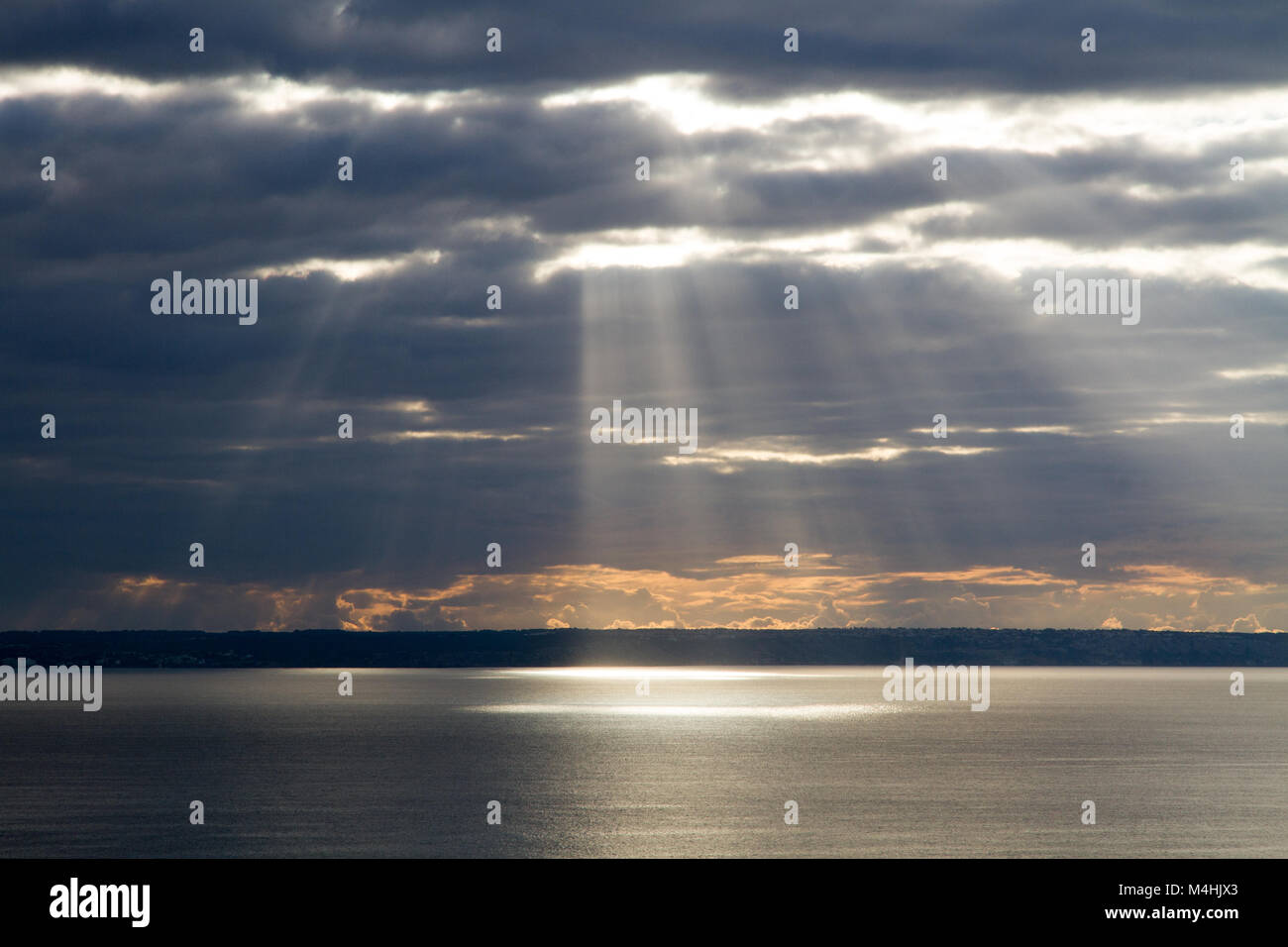 La luce del sole che riflette su acqua di mare vero le nuvole, in nuvoloso giorno meteo Foto Stock