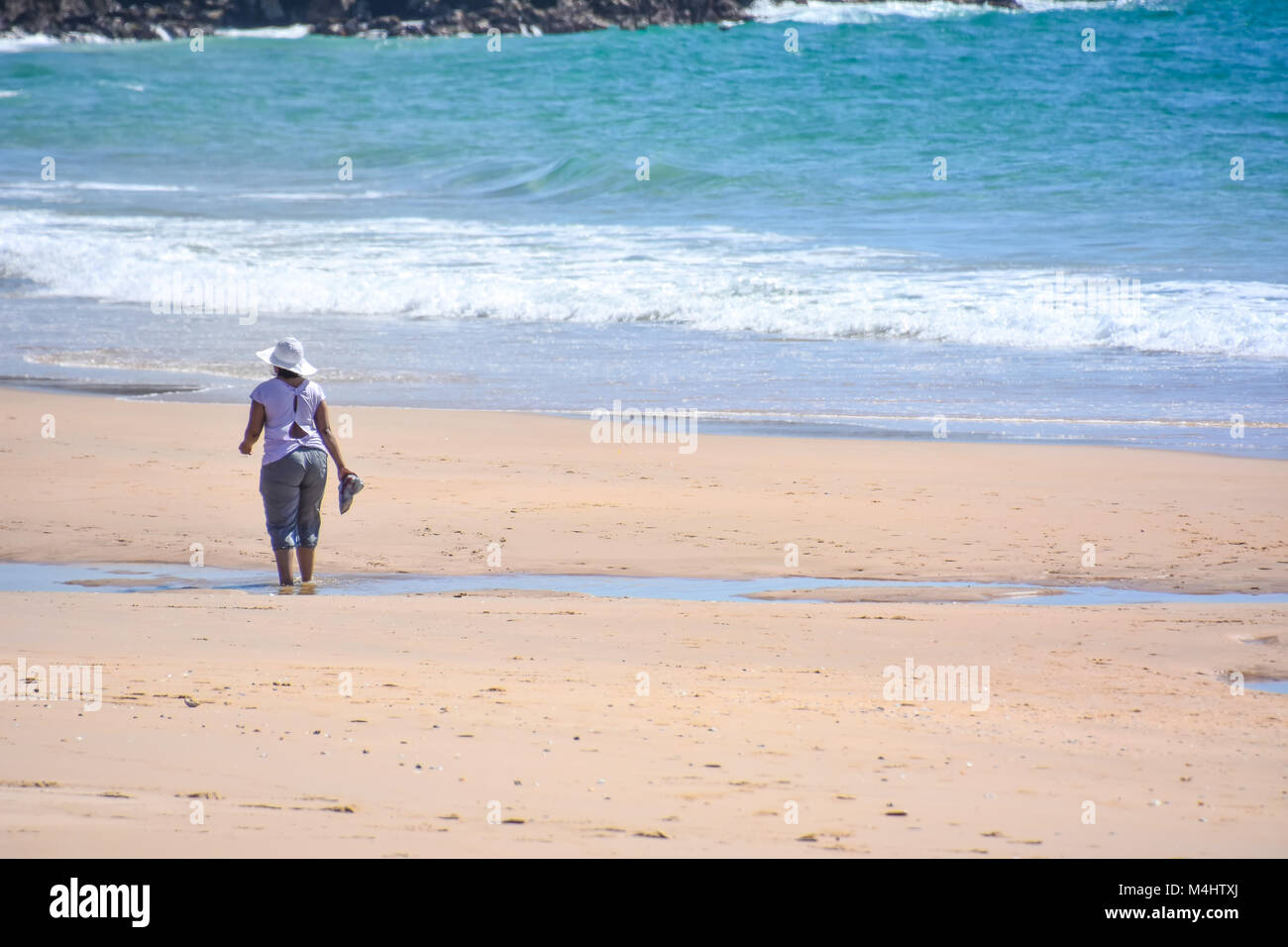 Un soggetto di sesso femminile di camminare sulla spiaggia di Robberg vicino a Plettenberg Bay in Sud Africa con oceano indiano in background Foto Stock