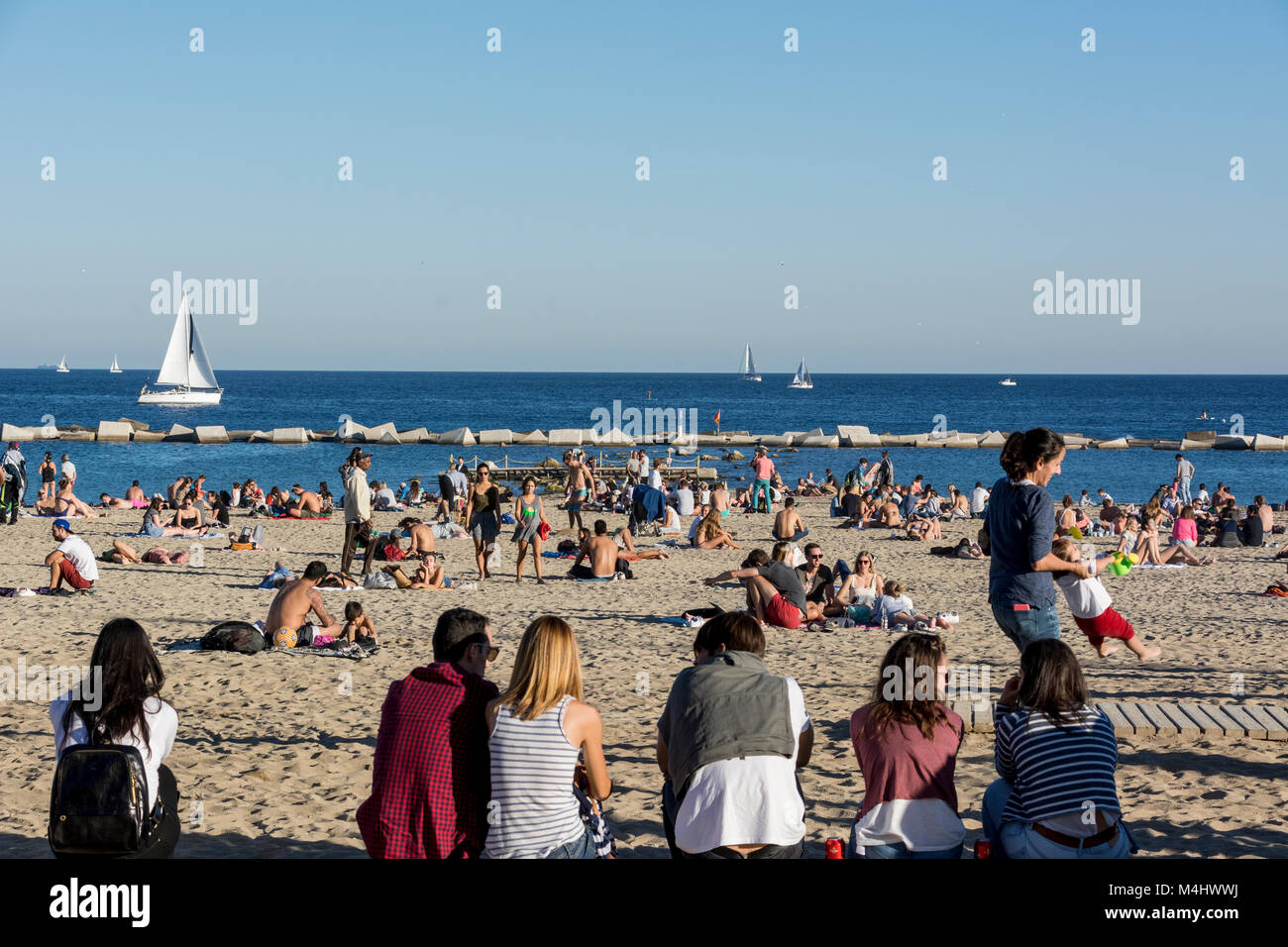 Strand von Barcellona un einem gut besuchten Sonntag im Herbst mit vielen Spaziergängern und Badenden Foto Stock