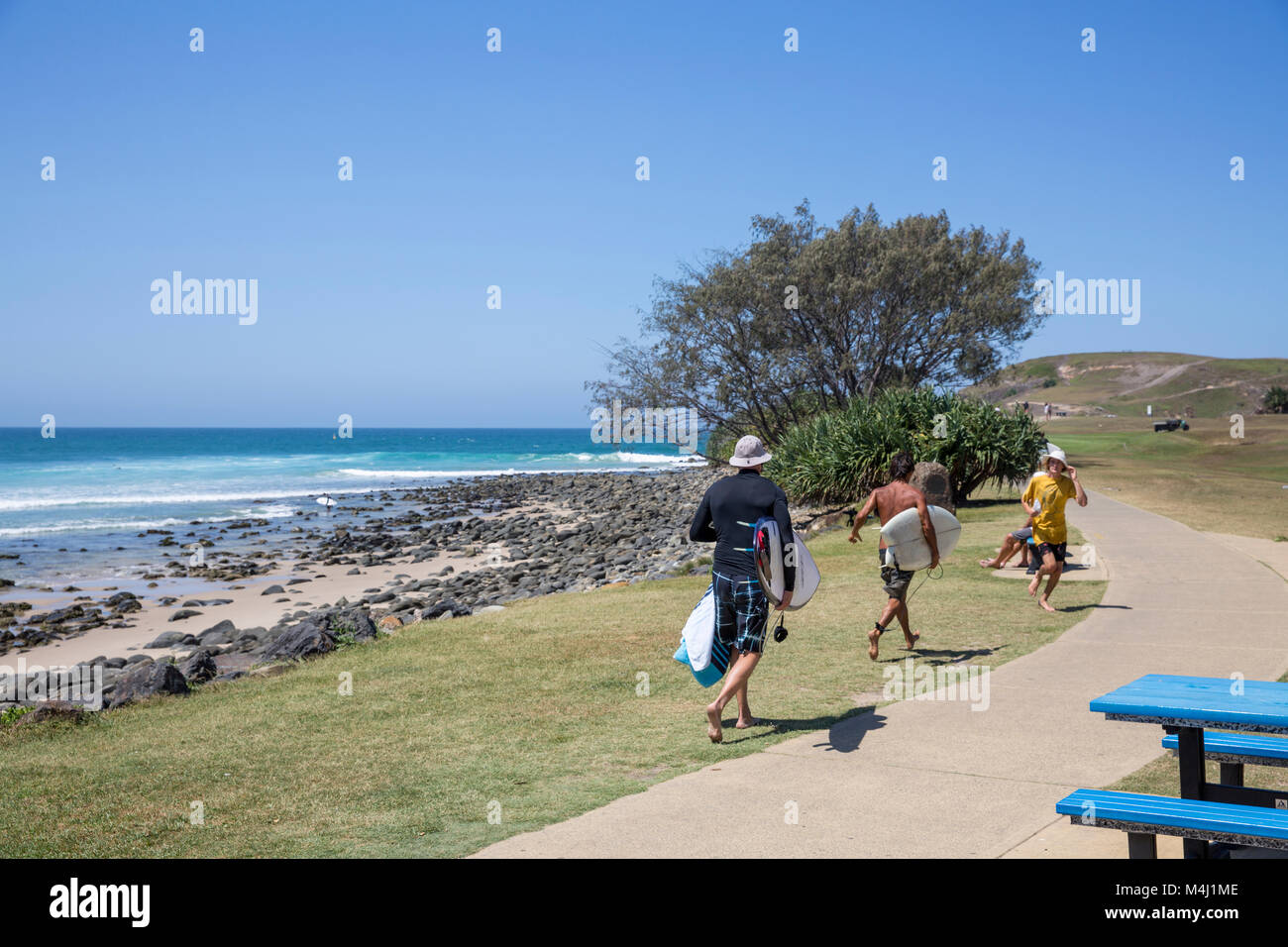 Tre maschi surfisti a Crescent Head surf beach sulla mezza costa nord del Nuovo Galles del Sud, Australia Foto Stock