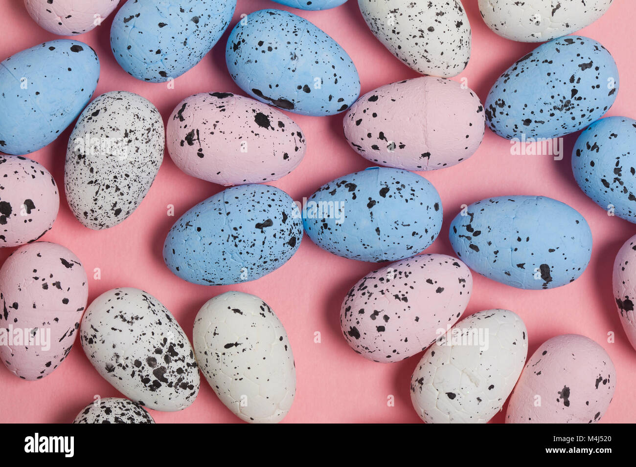 Una collezione di uova di pasqua su un pastello sfondo rosa Foto Stock