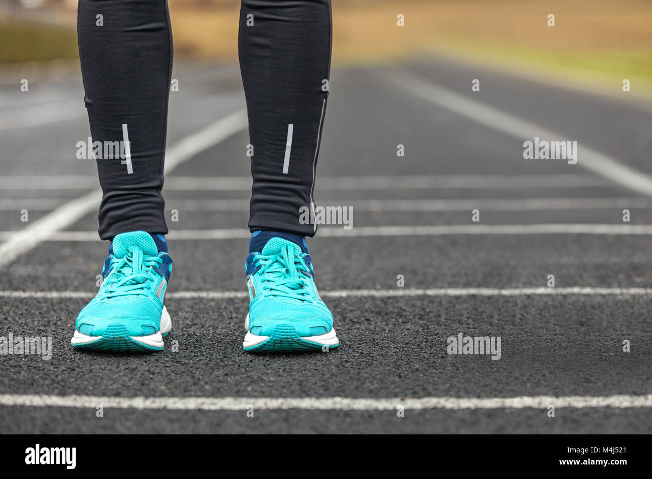 La donna per le gambe in blu con scarpe da corsa in piedi su asfalto Foto  stock - Alamy