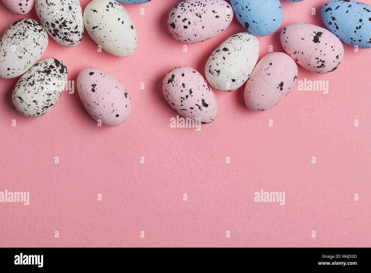 Una collezione di uova di pasqua su un pastello sfondo rosa Foto Stock