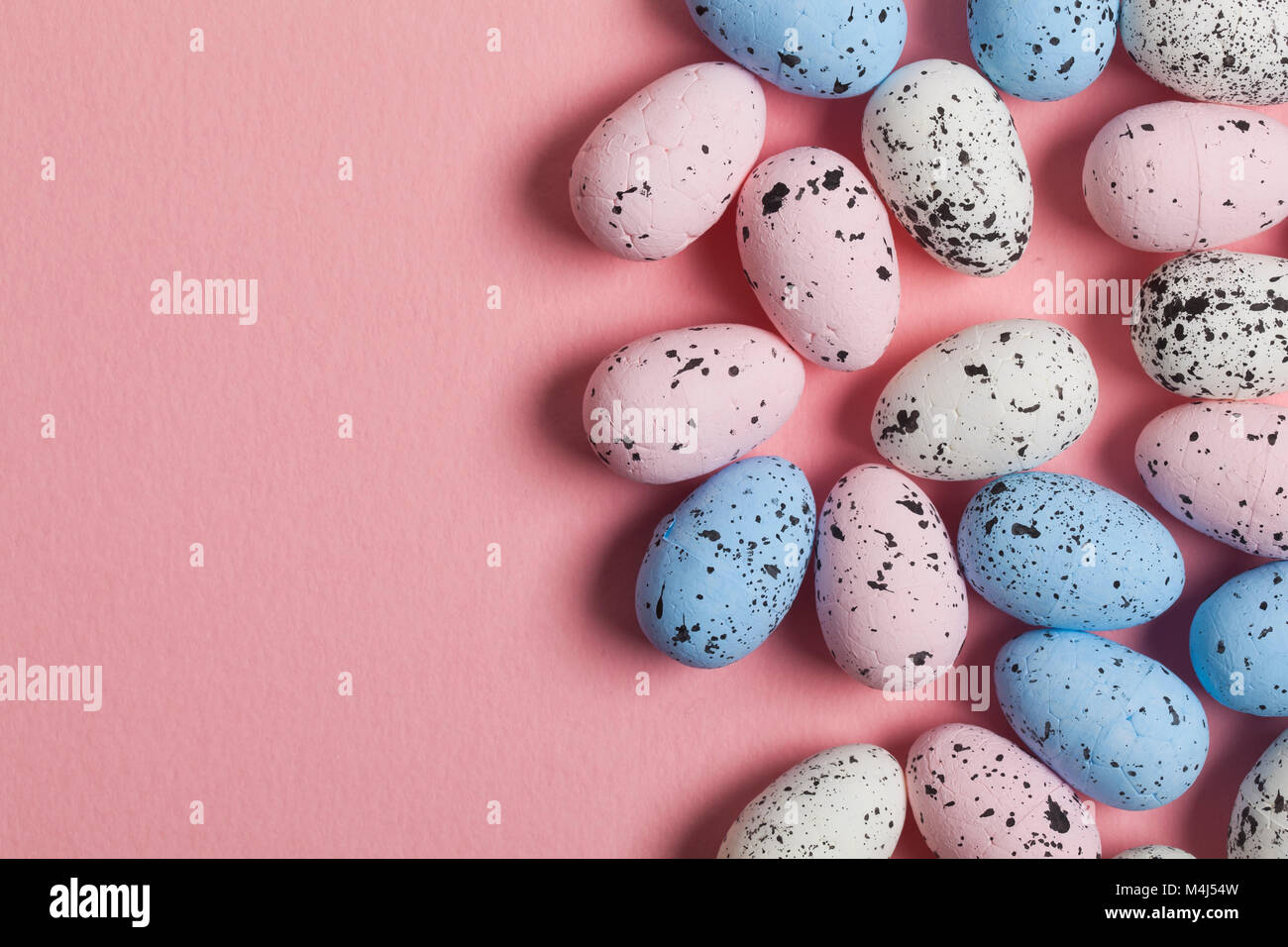 Una collezione di uova di pasqua su un pastello sfondo rosa Foto Stock