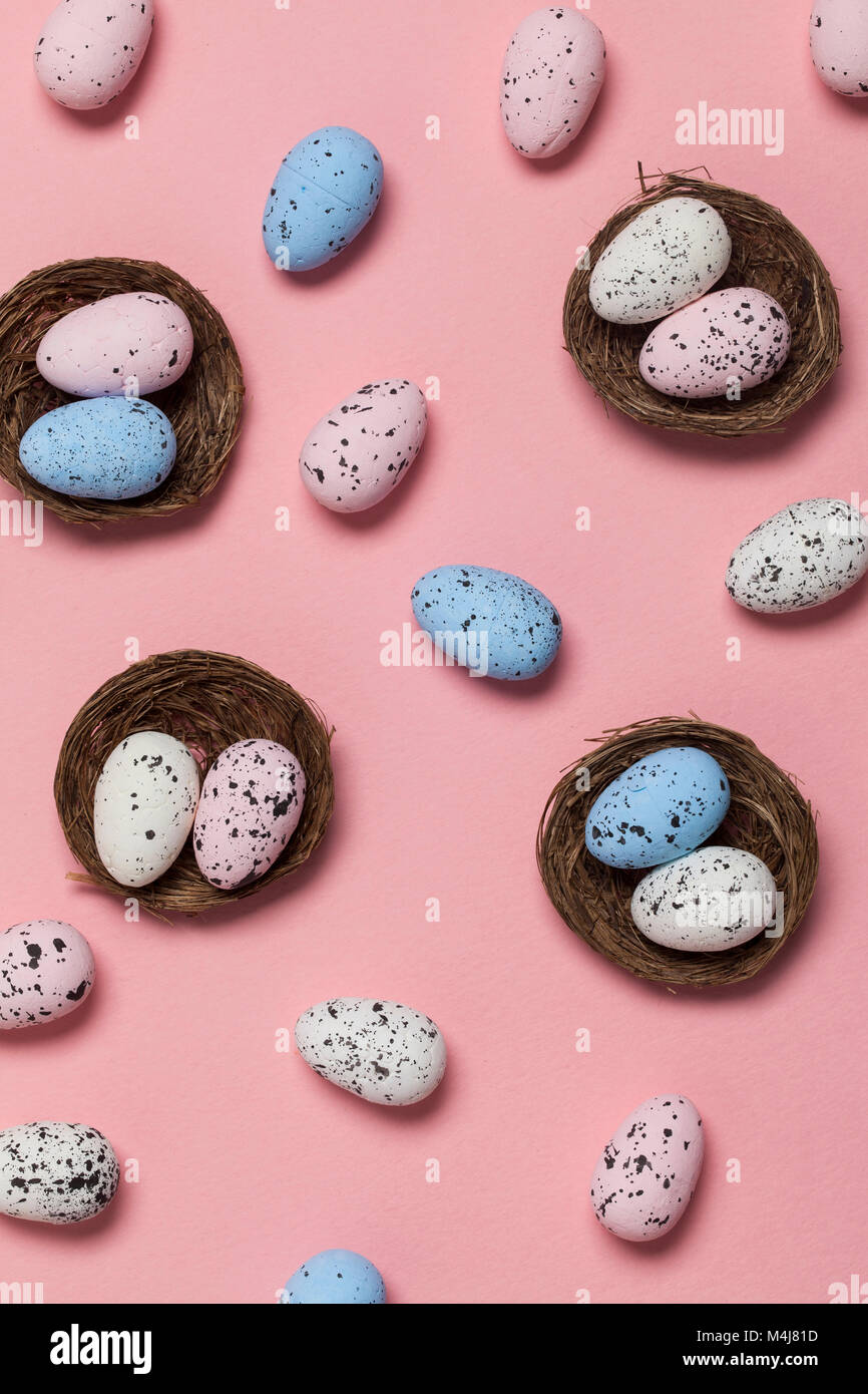 Uova di Pasqua in un nido su un pastello sfondo rosa Foto Stock