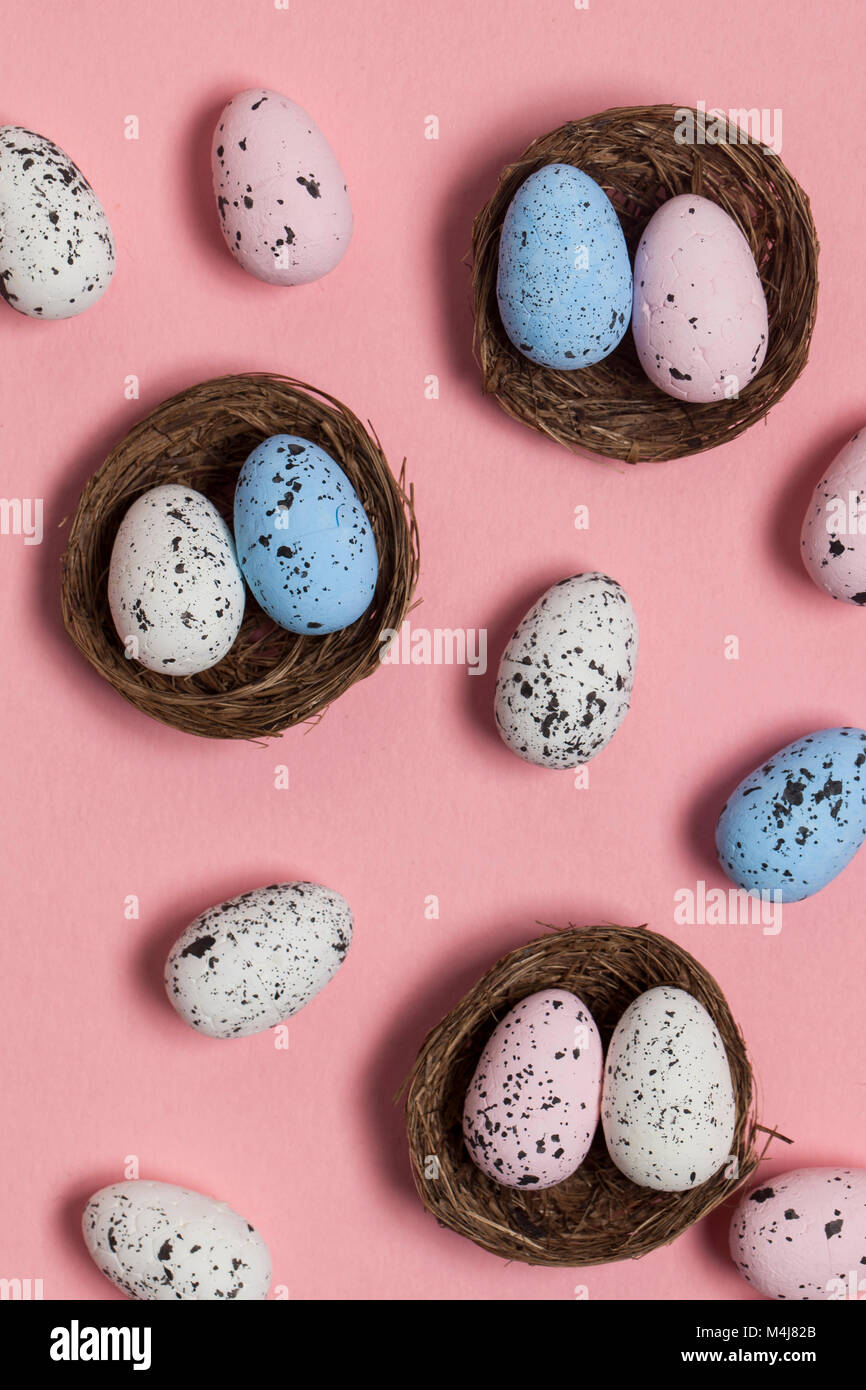 Uova di Pasqua in un nido su un pastello sfondo rosa Foto Stock