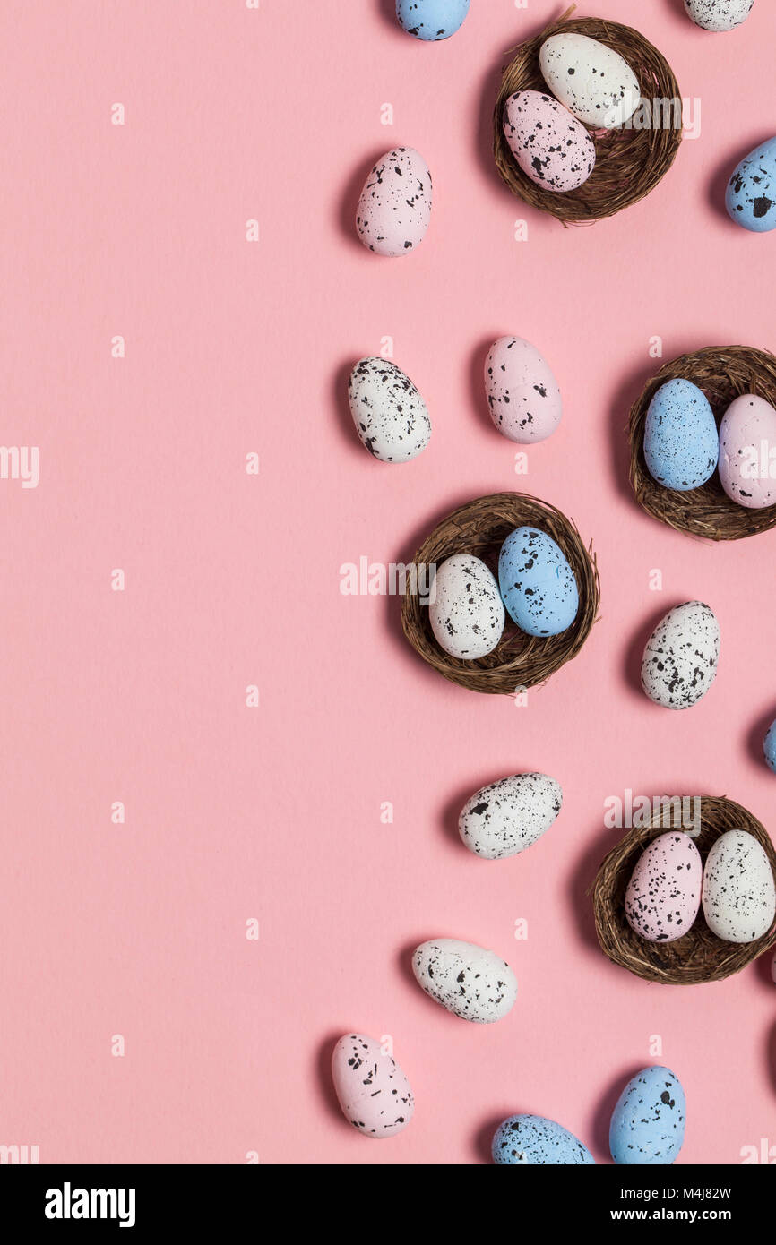 Uova di Pasqua in un nido su un pastello sfondo rosa Foto Stock