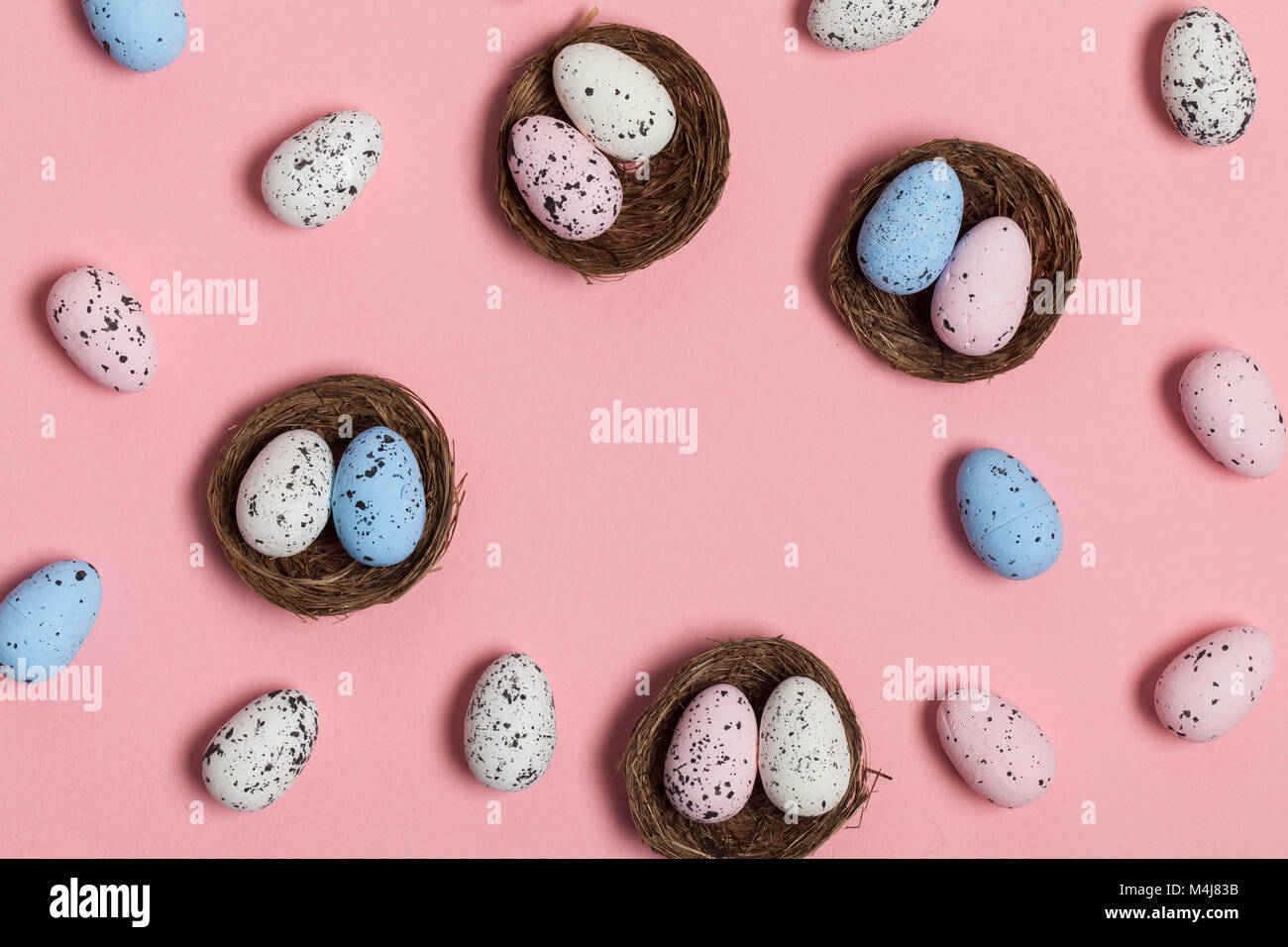 Uova di Pasqua in un nido su un pastello sfondo rosa Foto Stock