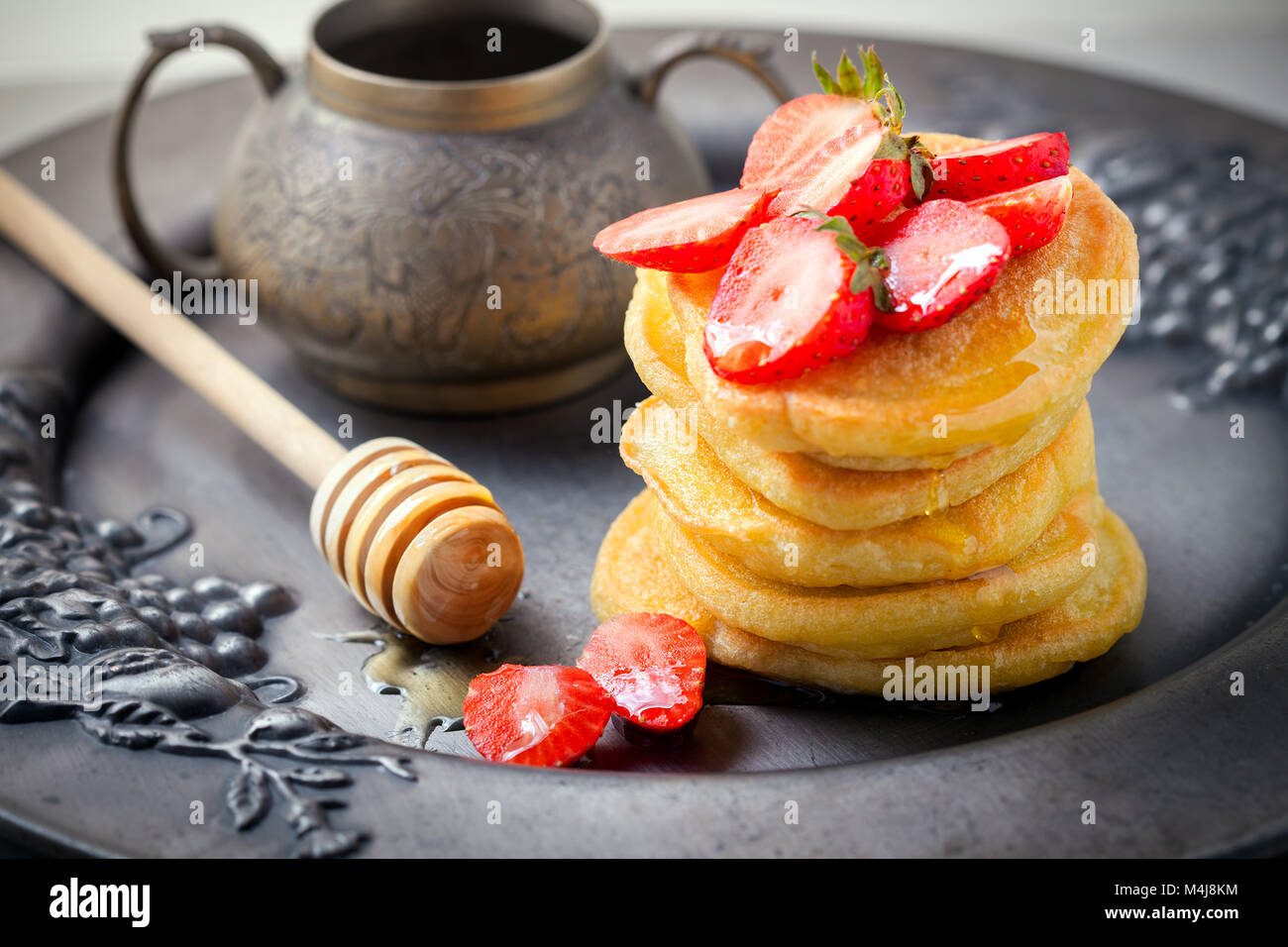 Pila di frittelle dolci con fragola e miele. Foto Stock