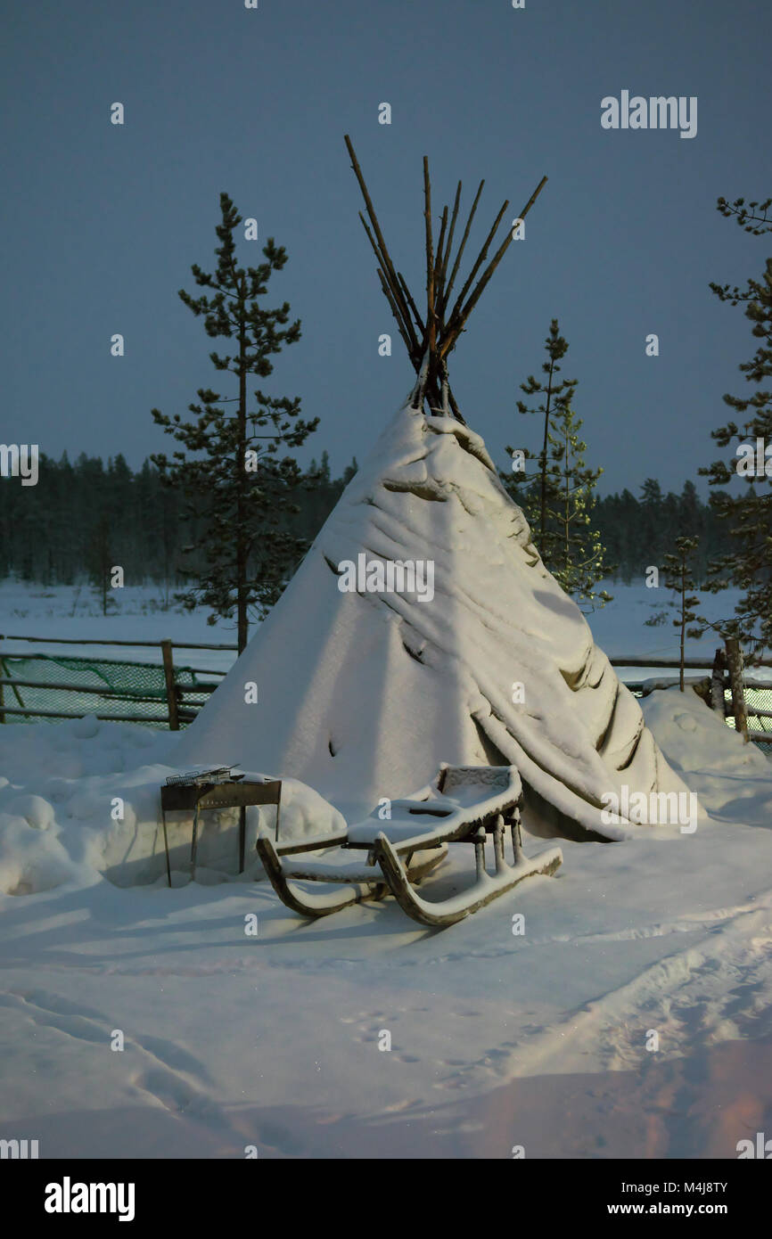 Tenda Sami e in piedi accanto alla slitta durante la notte polare Foto Stock