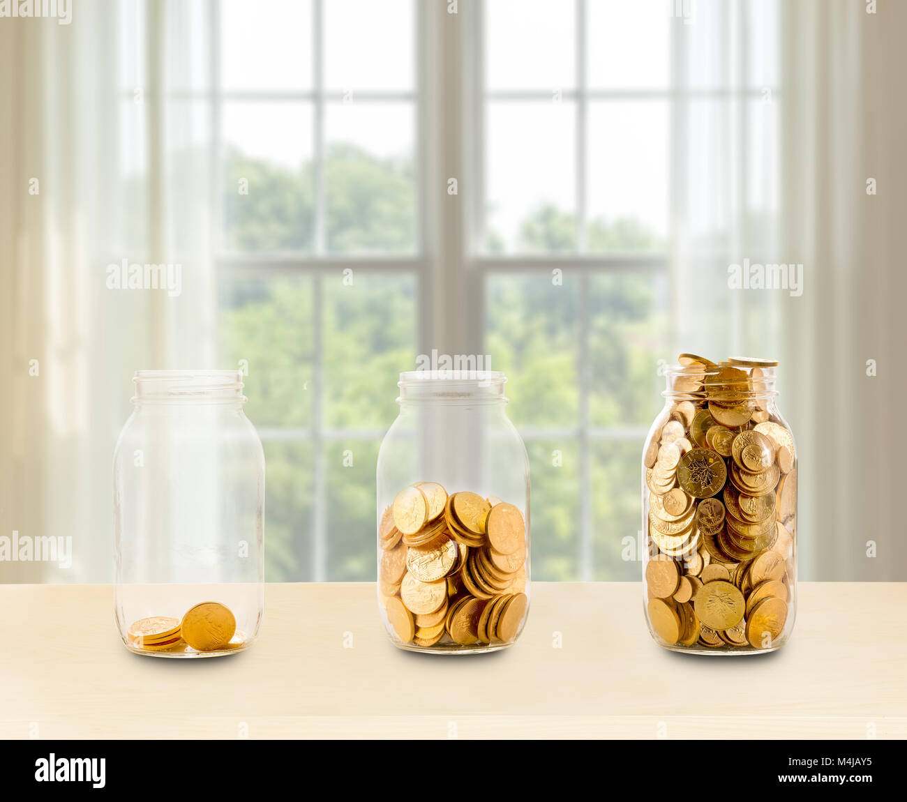 Tre vasi di vetro di risparmi crescenti sul ripiano Foto Stock