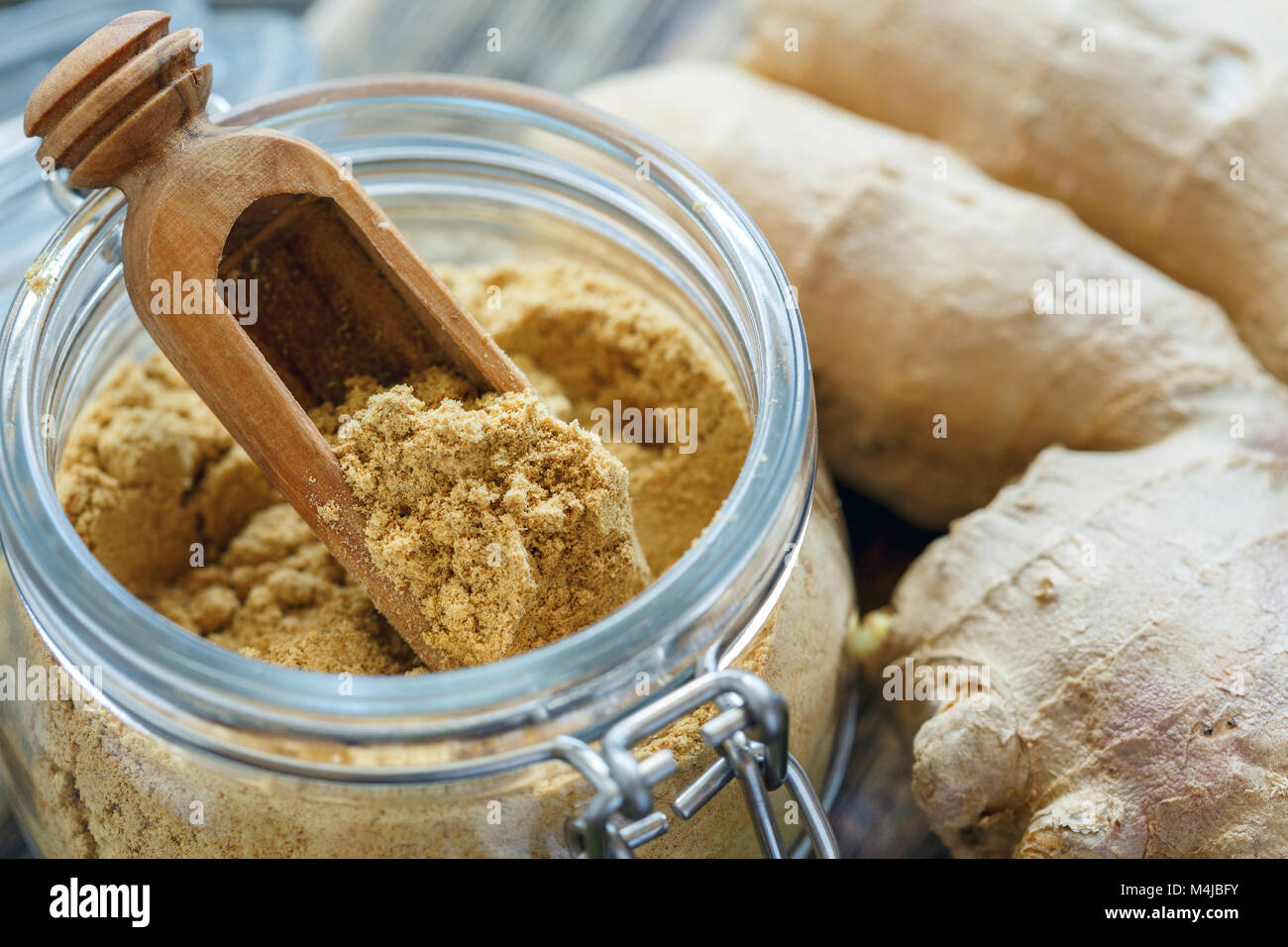 Cucchiaio di legno in un vasetto di zenzero in polvere. Foto Stock