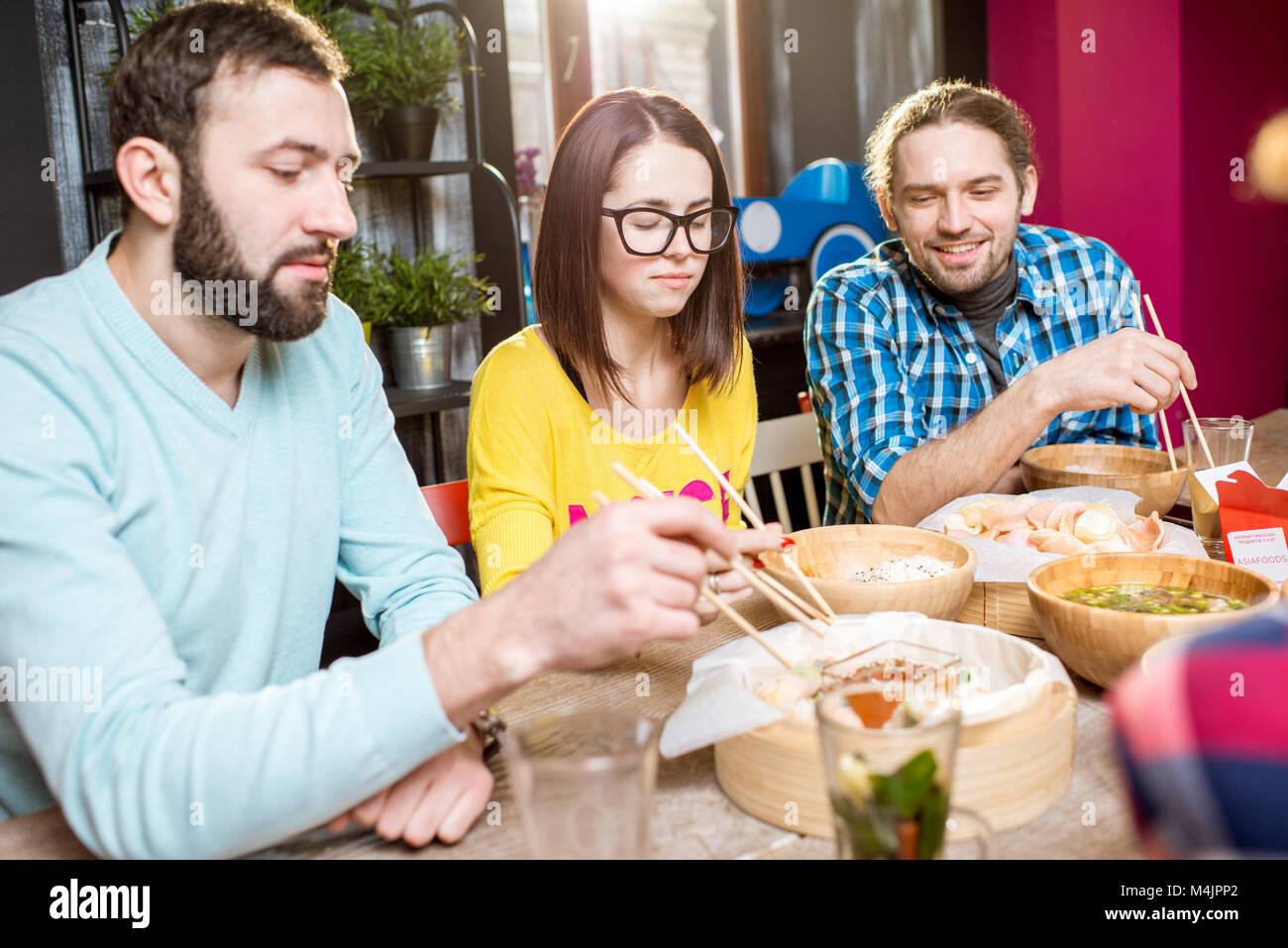 Amici asiatici mangiare pasti presso il ristorante Foto Stock