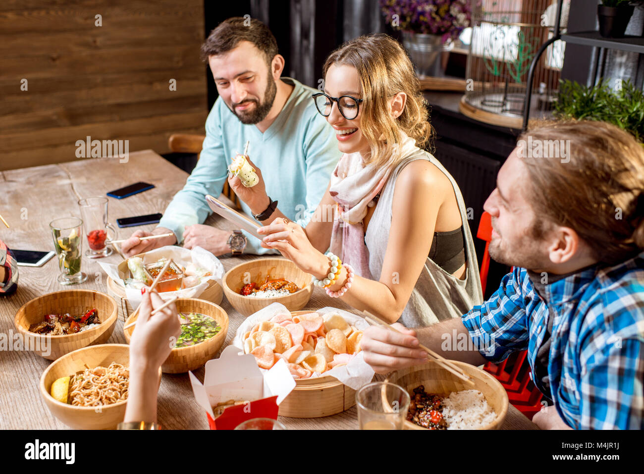 Amici asiatici mangiare pasti presso il ristorante Foto Stock