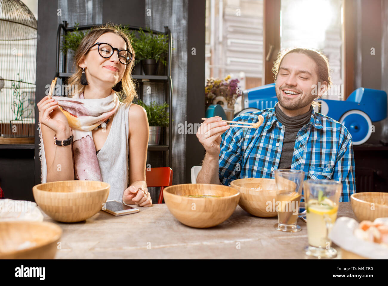 Amici asiatici mangiare pasti presso il ristorante Foto Stock