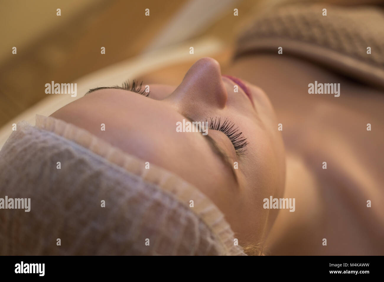 Donna ottenere trattamenti di bellezza mentre giaceva sul letto del salone Foto Stock