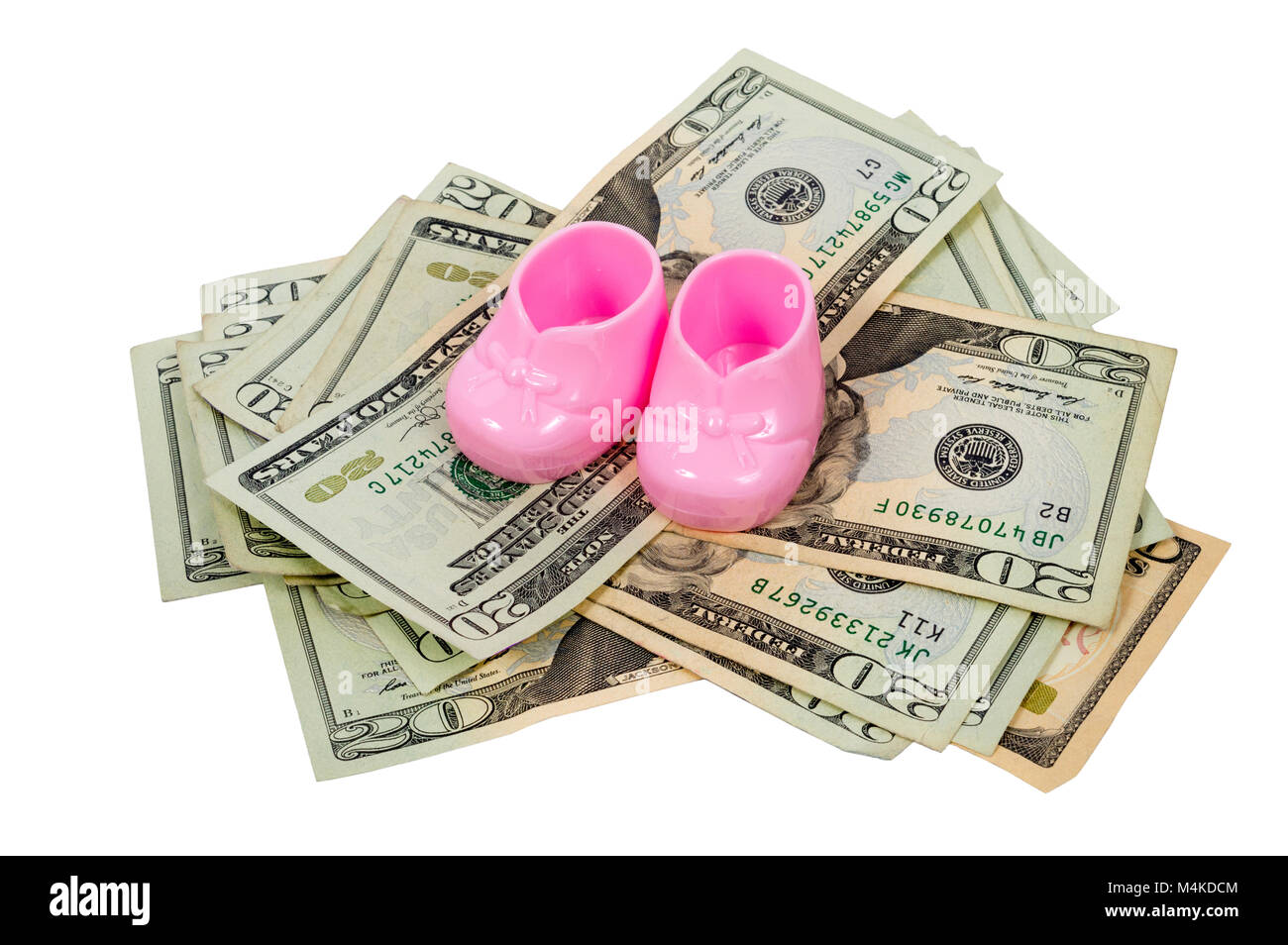 Inquadratura orizzontale di una coppia di plastica rosa babbucce bambino seduto sulla sommità di una pila di venti e dieci le fatture del dollaro su sfondo bianco Foto Stock