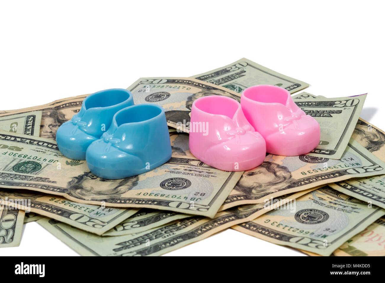 Inquadratura orizzontale di una coppia di blu e di plastica rosa babbucce bambino seduto su una pila di venti le fatture del dollaro su uno sfondo bianco. Foto Stock