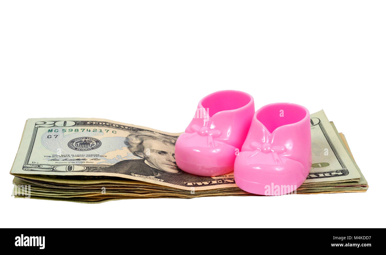 Inquadratura orizzontale di una coppia di plastica rosa babbucce bambino seduto sulla sommità di una pila di venti le fatture del dollaro su uno sfondo bianco. Foto Stock