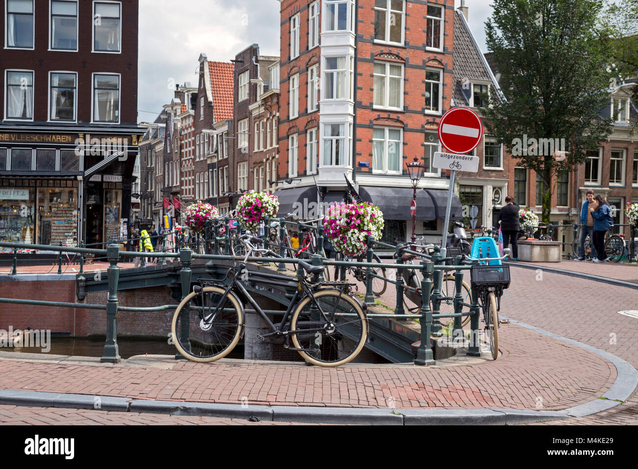 Tipico angolo di strada di Amsterdam che mostra le moto, canal, retail e gli edifici residenziali, Foto Stock