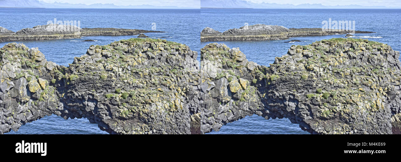La costa e le scogliere di rocce basaltiche a Arnarstapi riserva naturale visibile attraverso il foro nella scogliera. Penisola Snaefellsness, Islanda Foto Stock
