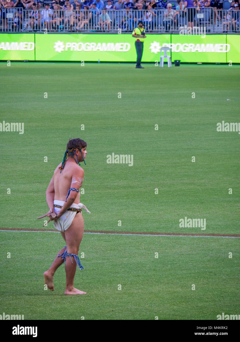 Un uomo indigeni eseguendo una tradizionale danza accogliente a Fremantle Dockers donne gioco a Optus Stadium, Perth, WA, Australia. Foto Stock